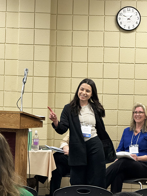 Two women smiling in the front of the conference room