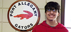 Levi Culver standing next to Port Allegany Gators plaque on wall