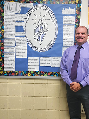 Mr. Young proudly standing next to NTHS bulletin board