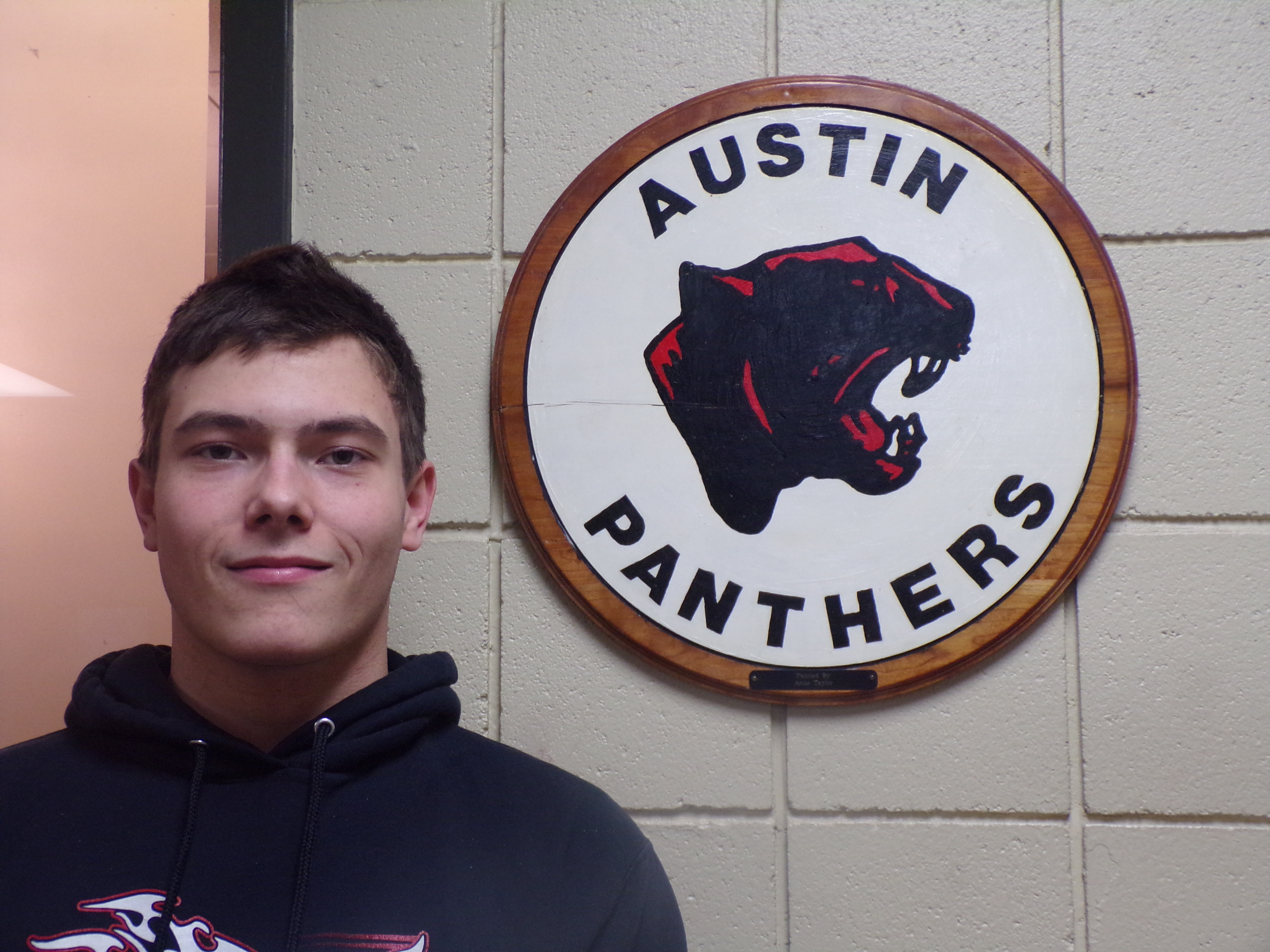 William Ice in front of Austin Panthers logo