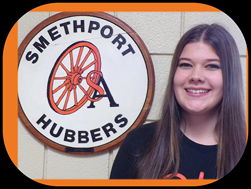 Madison Ness next to Smethport Hubber logo on the wall