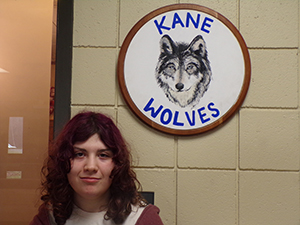 Novalee Corliss next to school mascot on the wall