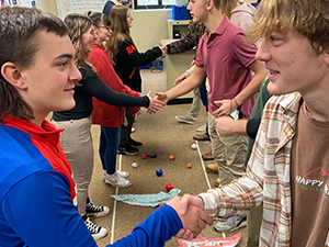 Students shaking hands during competition