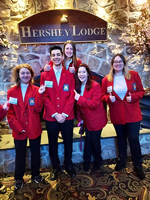 Five students in red jackets in front of Hershey Lodge