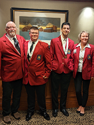 Four attendees wearing red jackets