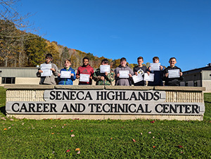 Six Seneca Highlands Career and Technical Center students with cybersecurity certificates standing behind SHCTC sign