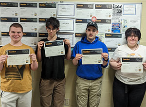 Four students holding their certificates