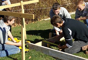 Students outside building a frame for a structure