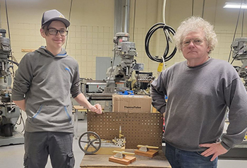 Doug and Mr. Cox posing for a picture with Doug's steam engine project